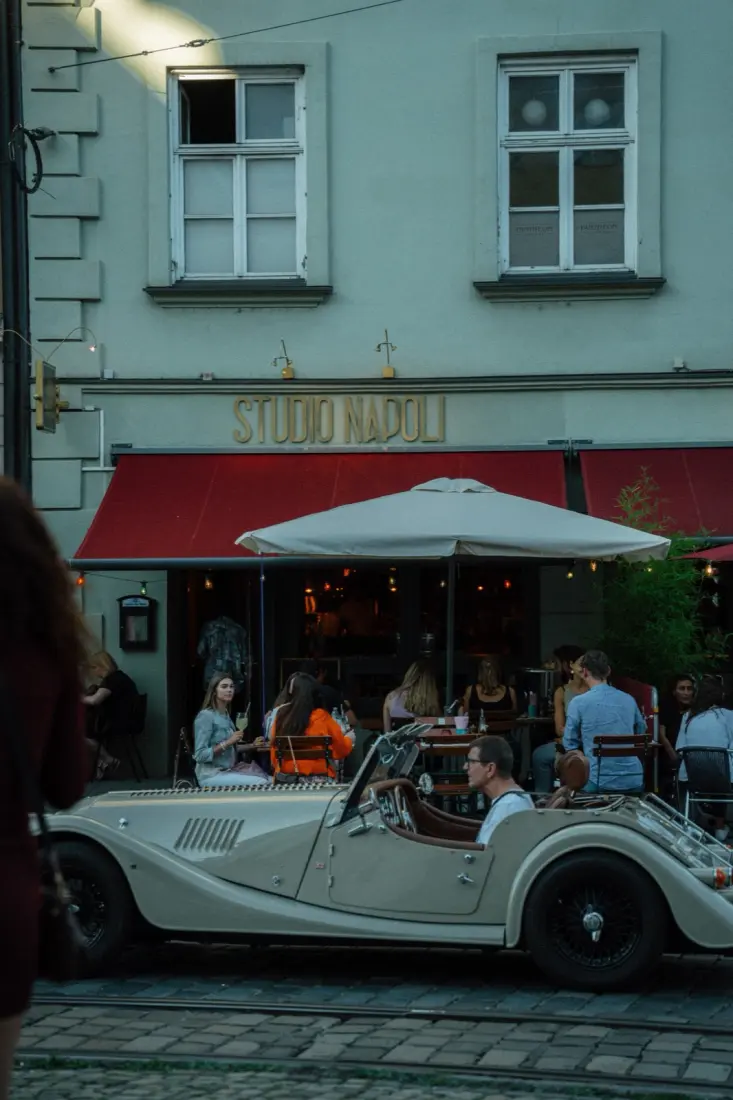 Studio Napoli Fassade mit Vintage-Cabrio am Abend